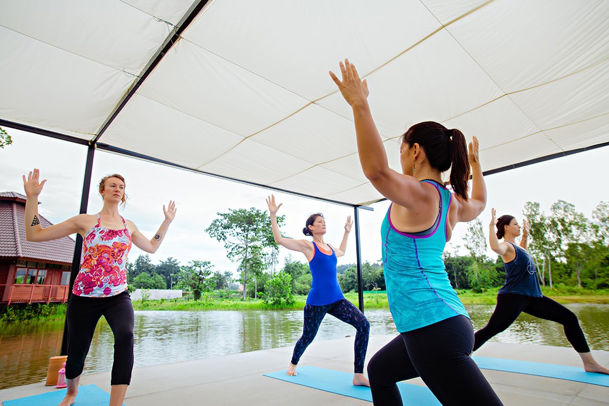 Guests practising yoga in Museflower's open-air lakeside sala