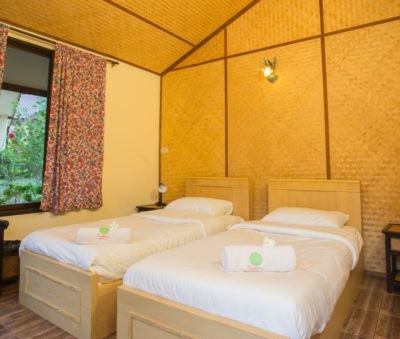A bright twin guest room with woven bamboo walls